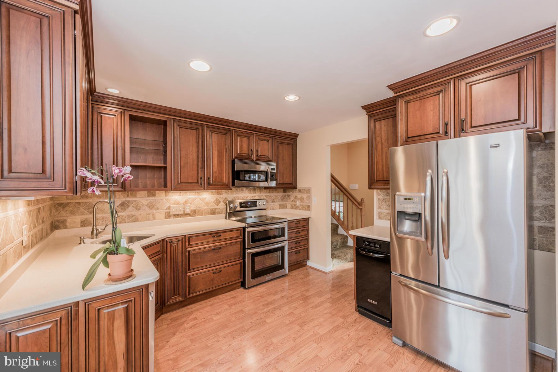 9466 Good Lion Road Columbia, MD 21045 - Photo 2 of 26 a kitchen with stainless steel appliances granite countertop a refrigerator stove microwave and sink