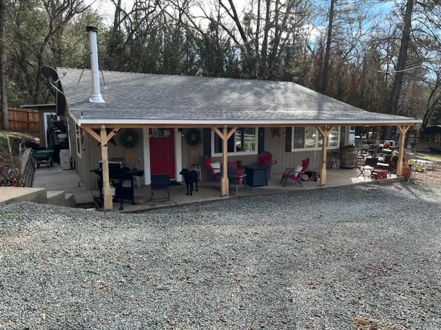 a view of a wooden house with large trees