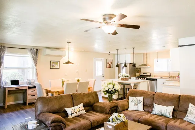 a living room with kitchen island furniture and a flat screen tv