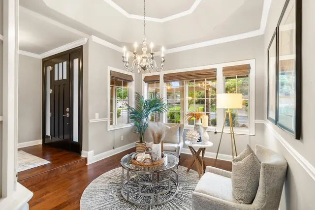 a view of a hallway with dining area and chandelier