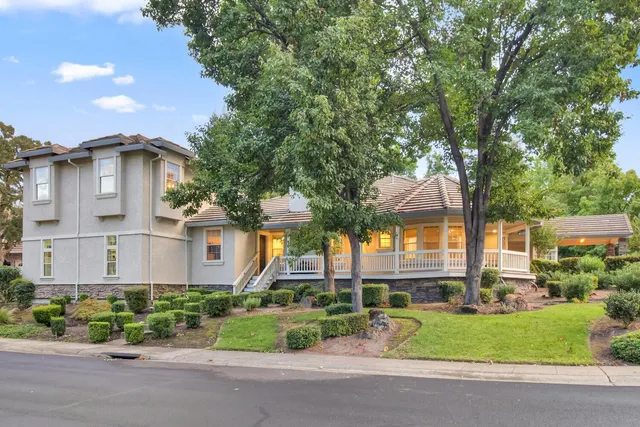 a front view of a house with a garden and plants