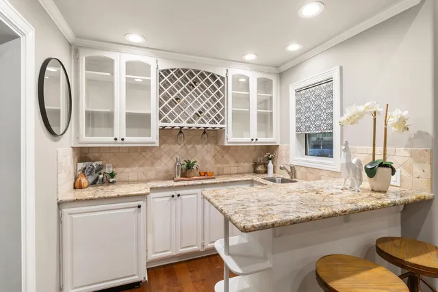 a kitchen with kitchen island granite countertop a sink cabinets and stainless steel appliances
