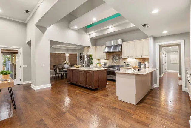 a dining room with furniture a chandelier and wooden floor