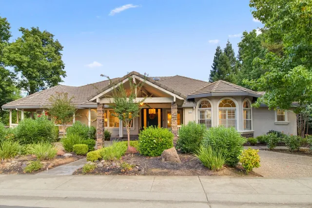 a front view of a house with a yard and potted plants