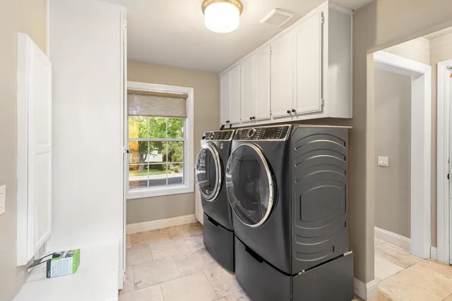 a front view of a house with a garden and trees