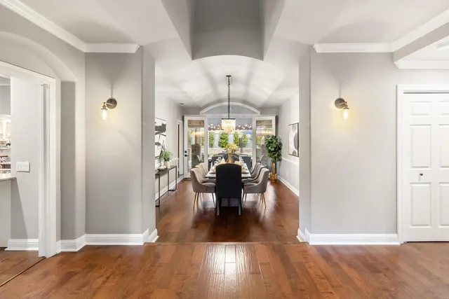 a dining room with furniture a chandelier and wooden floor