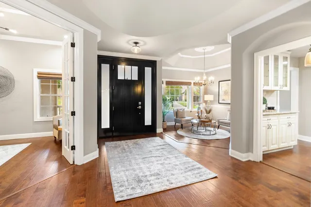 a living room with furniture chandelier and wooden floor