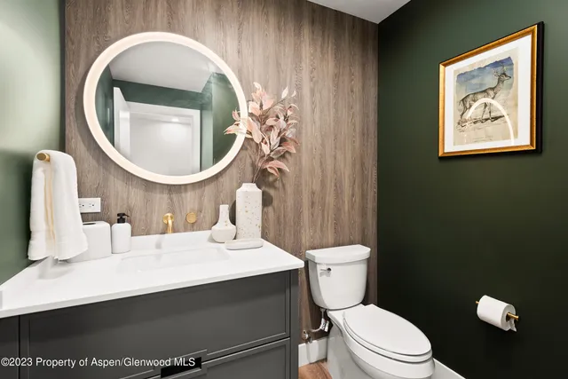 a bathroom with a toilet a sink and mirror