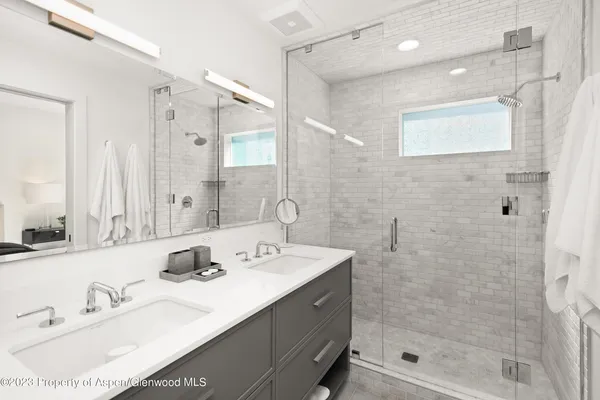 a bathroom with a double vanity sink mirror and shower