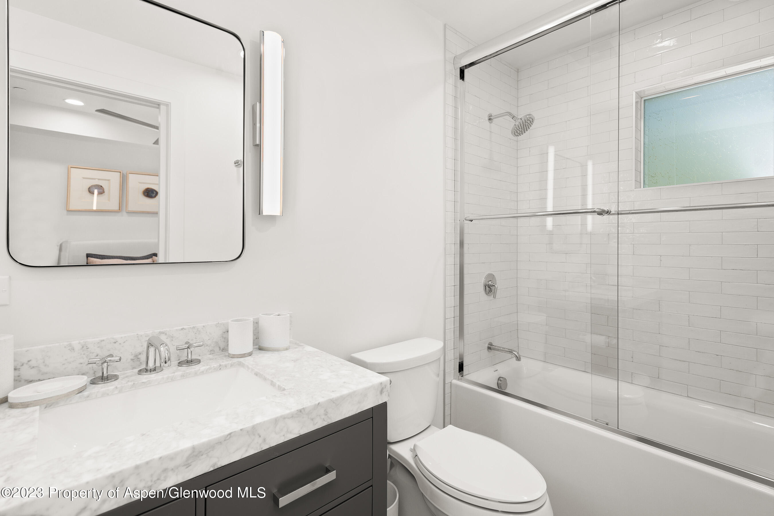 22842 Two Rivers Road, Unit 100 Basalt, CO 81621 - Photo 17 of 22 a bathroom with a granite countertop sink toilet mirror and shower