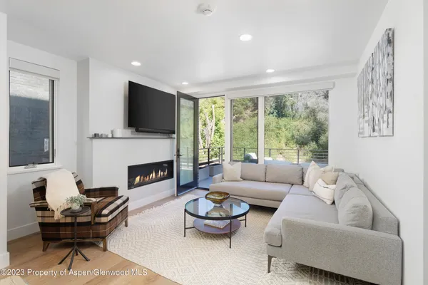 a living room with furniture a fireplace and a large window
