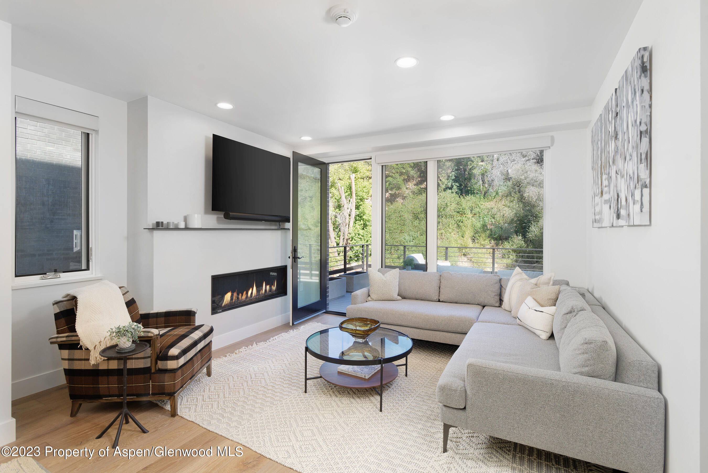 22842 Two Rivers Road, Unit 100 Basalt, CO 81621 - Photo 2 of 22 a living room with furniture a fireplace and a large window