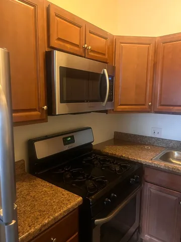 a kitchen with granite countertop cabinets and steel stainless steel appliances