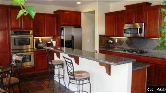 615 Royal Windsor Court Reno, NV 89521 - Photo 2 of 13 a kitchen with wooden cabinets a refrigerator and a stove