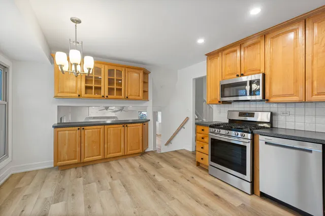a kitchen with stainless steel appliances granite countertop wooden cabinets stove top oven and sink