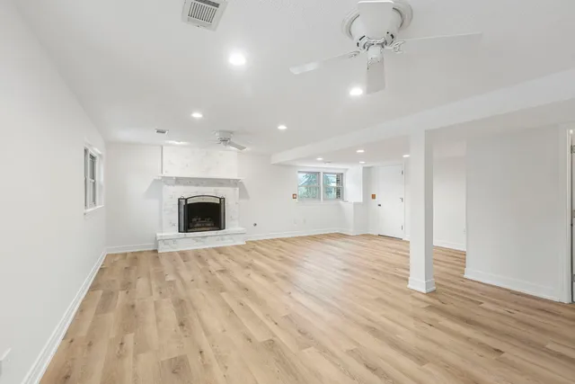a view of empty room with wooden floor and fireplace