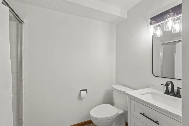 a bathroom with a toilet a sink and mirror