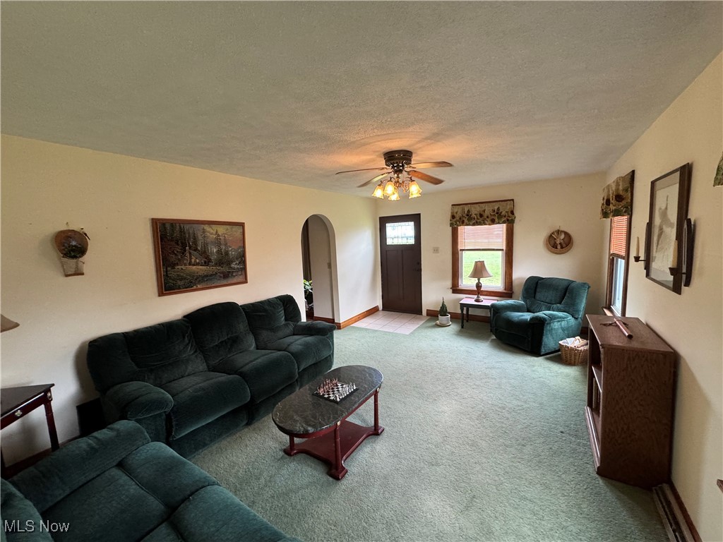 71322 Sharon Road Bridgeport, OH 43912 - Photo 24 of 39 Carpeted living room featuring arched walkways, a ceiling fan, a textured ceiling, and baseboards