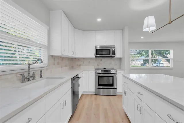 a kitchen with a refrigerator a stove a sink and a microwave