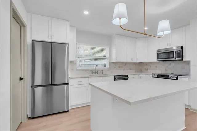 a kitchen with stainless steel appliances white cabinets and a sink