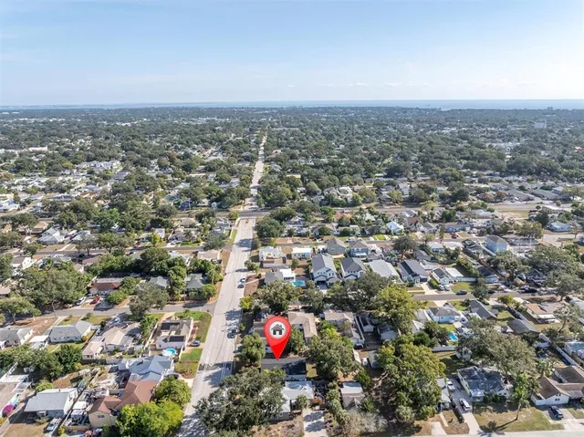 a view of a house with a yard and large tree