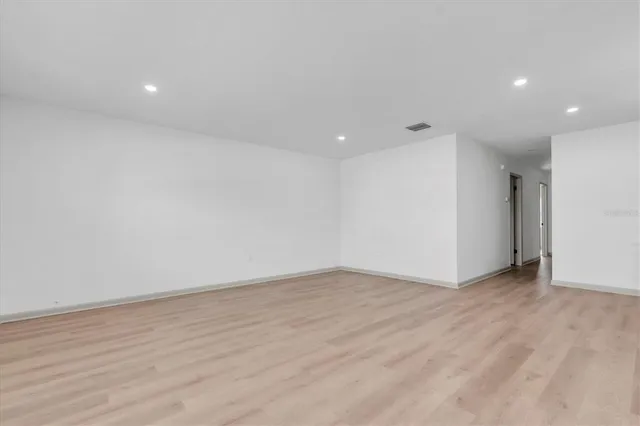 a kitchen with a refrigerator a sink and dishwasher with wooden floor