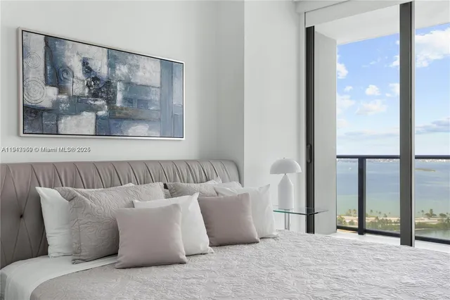 a bed room with a large bed and a painting on the wall