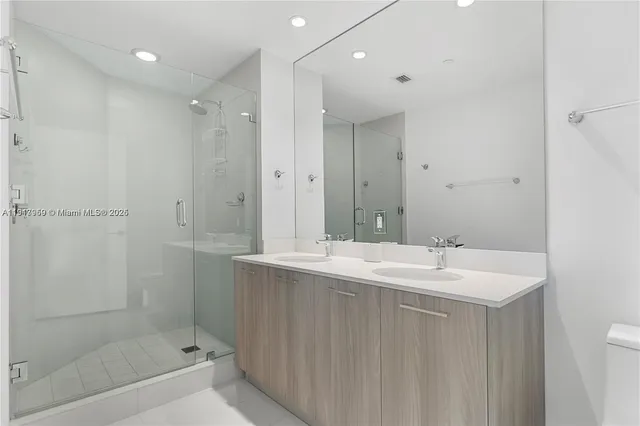 a bathroom with a shower sink and mirror