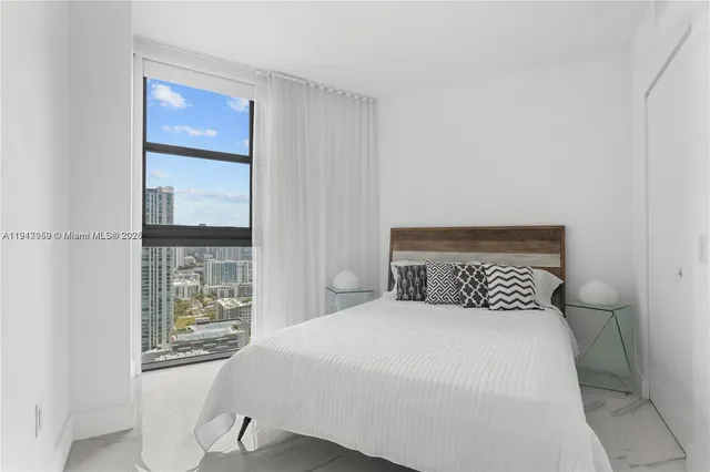 a bedroom with a large bed and a window