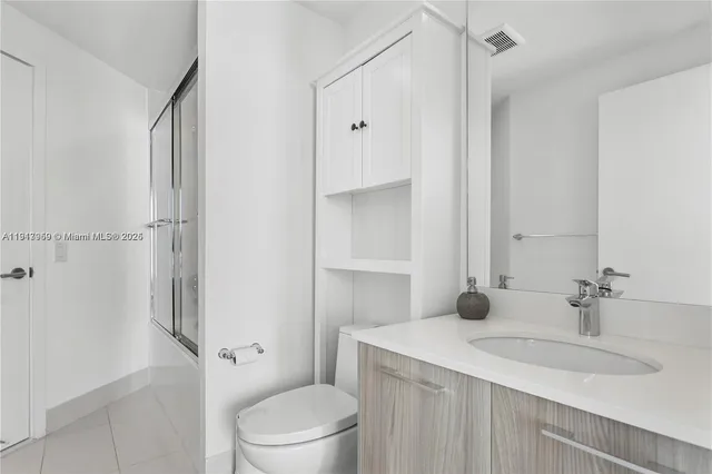 a bathroom with a sink toilet vanity and shower