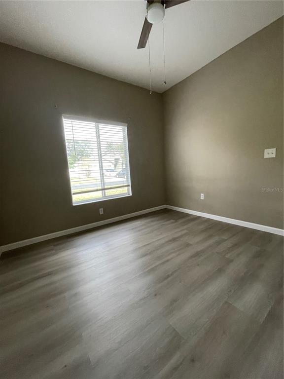 4939 Woodmere Road Land O Lakes, FL 34639 - Photo 18 of 43 an empty room with wooden floor and windows