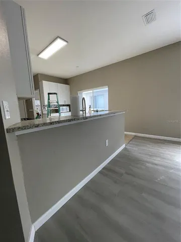 a kitchen with stainless steel appliances granite countertop a sink window and cabinets