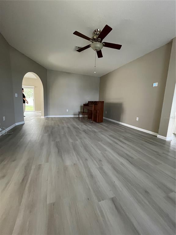 4939 Woodmere Road Land O Lakes, FL 34639 - Photo 20 of 43 an empty room with wooden floor and a ceiling fan