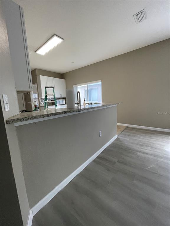 4939 Woodmere Road Land O Lakes, FL 34639 - Photo 21 of 43 a kitchen with stainless steel appliances granite countertop a sink window and cabinets