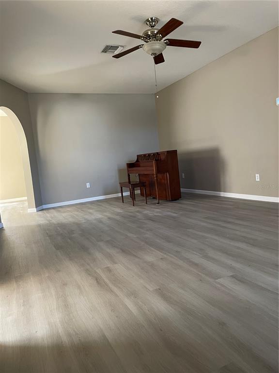 4939 Woodmere Road Land O Lakes, FL 34639 - Photo 33 of 43 a room with a ceiling fan and wooden floor