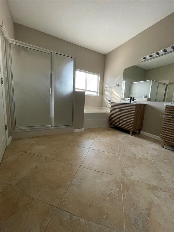 4939 Woodmere Road Land O Lakes, FL 34639 - Photo 35 of 43 a bathroom with a tub shower and sink