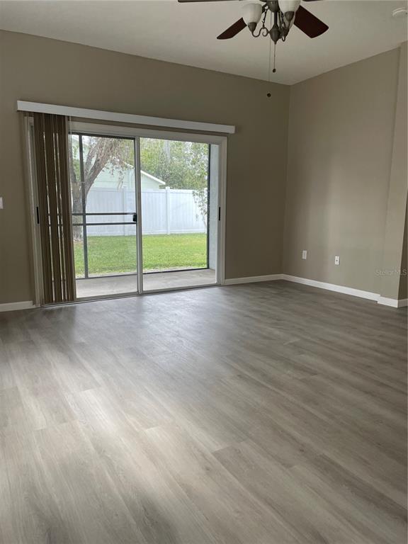 4939 Woodmere Road Land O Lakes, FL 34639 - Photo 4 of 43 a view of an empty room with wooden floor and a window