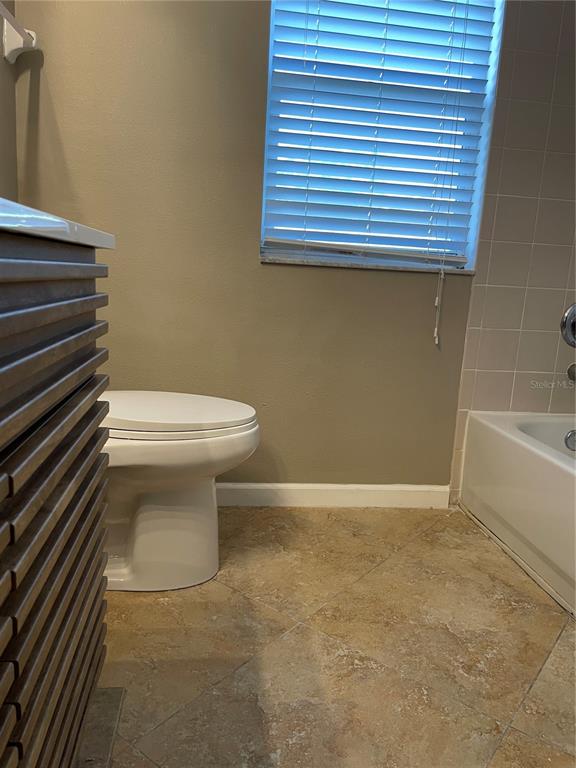 4939 Woodmere Road Land O Lakes, FL 34639 - Photo 42 of 43 a bathroom with a toilet and a bathtub