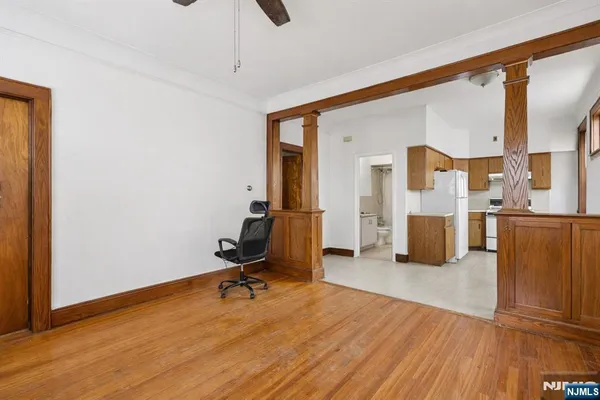 a view of a livingroom with wooden floor and a workspace