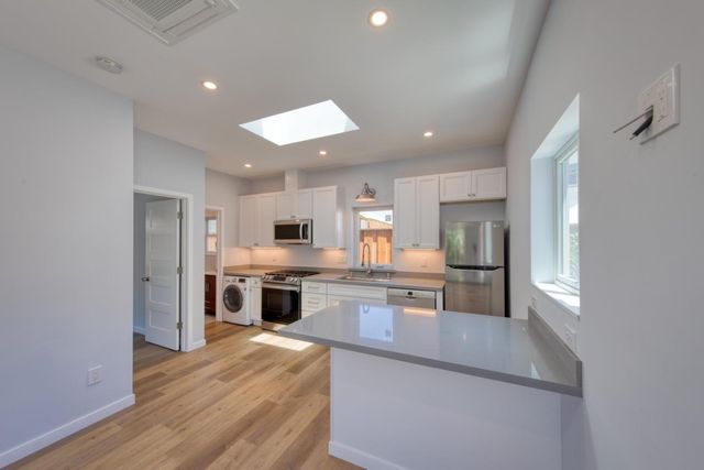 a kitchen with stainless steel appliances granite countertop a refrigerator and a stove top oven