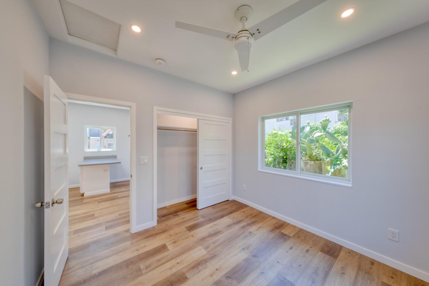 1439 38th Avenue Oakland, CA 94601 - Photo 4 of 15 an empty room with wooden floor cabinet and windows