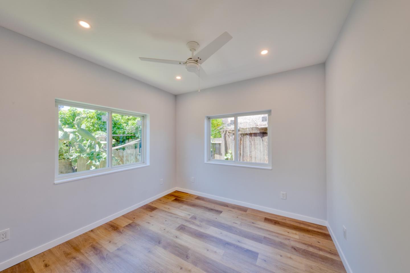 1439 38th Avenue Oakland, CA 94601 - Photo 5 of 15 an empty room with wooden floor and windows