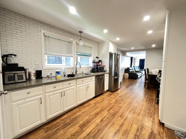 a kitchen with sink cabinets and wooden floor
