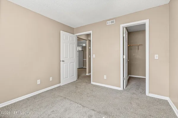 an empty room with closet and a bathroom