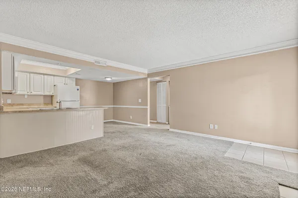a view of kitchen with white cabinets and wooden floors