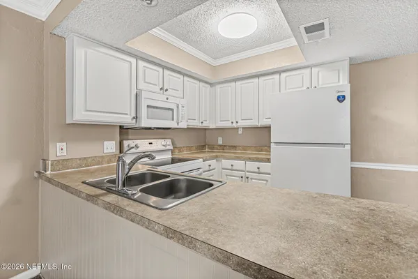 a kitchen with stainless steel appliances granite countertop a sink refrigerator and cabinets