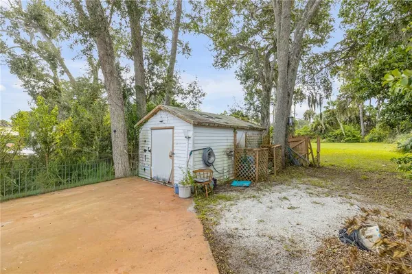 a view of a house with backyard and trees