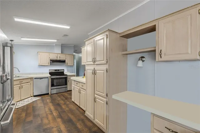 a kitchen with a refrigerator a stove top oven a sink and dishwasher