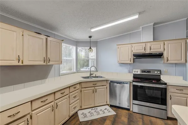 a kitchen with granite countertop a sink a stove and cabinets