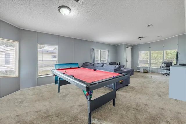 a room with pool table and windows